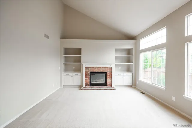 an empty room with a fireplace and window