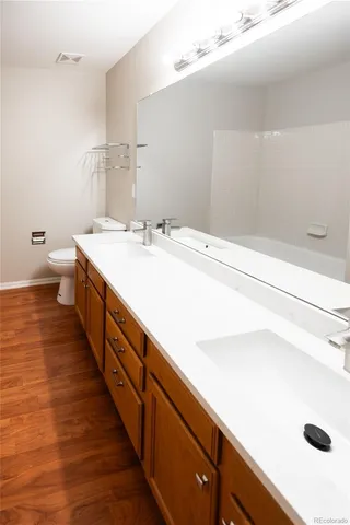 a bathroom with a double vanity sink and a mirror