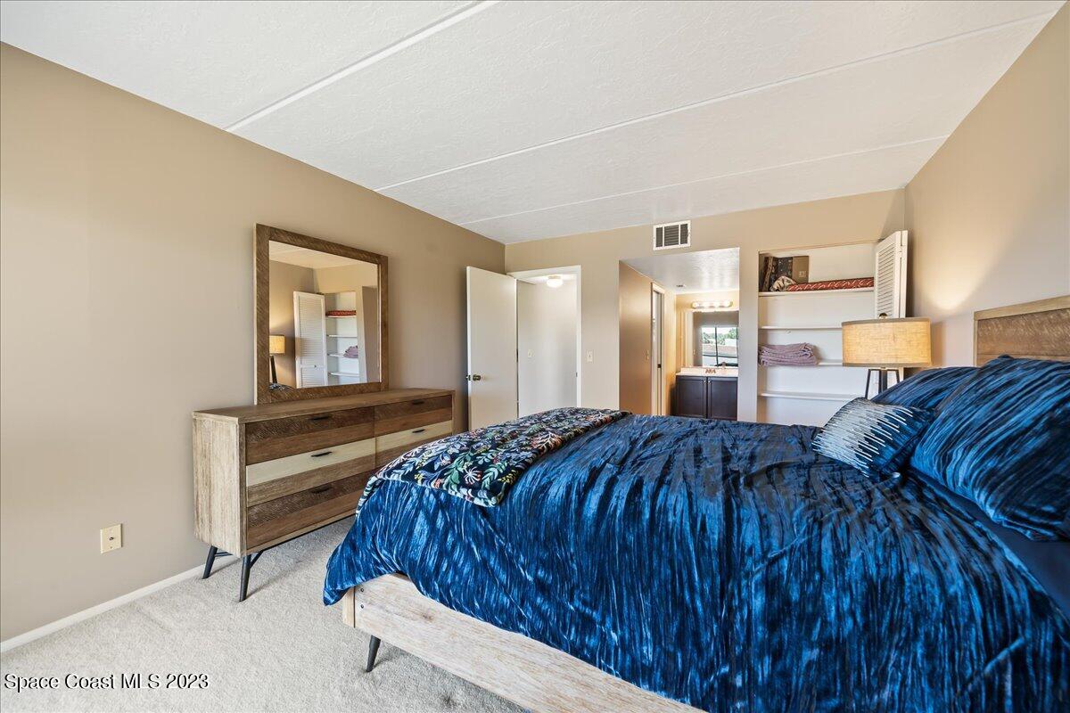 2775 North Wickham Road, Unit 204 Melbourne, FL 32935 - Photo 13 of 24 a bedroom with a bed and a dresser