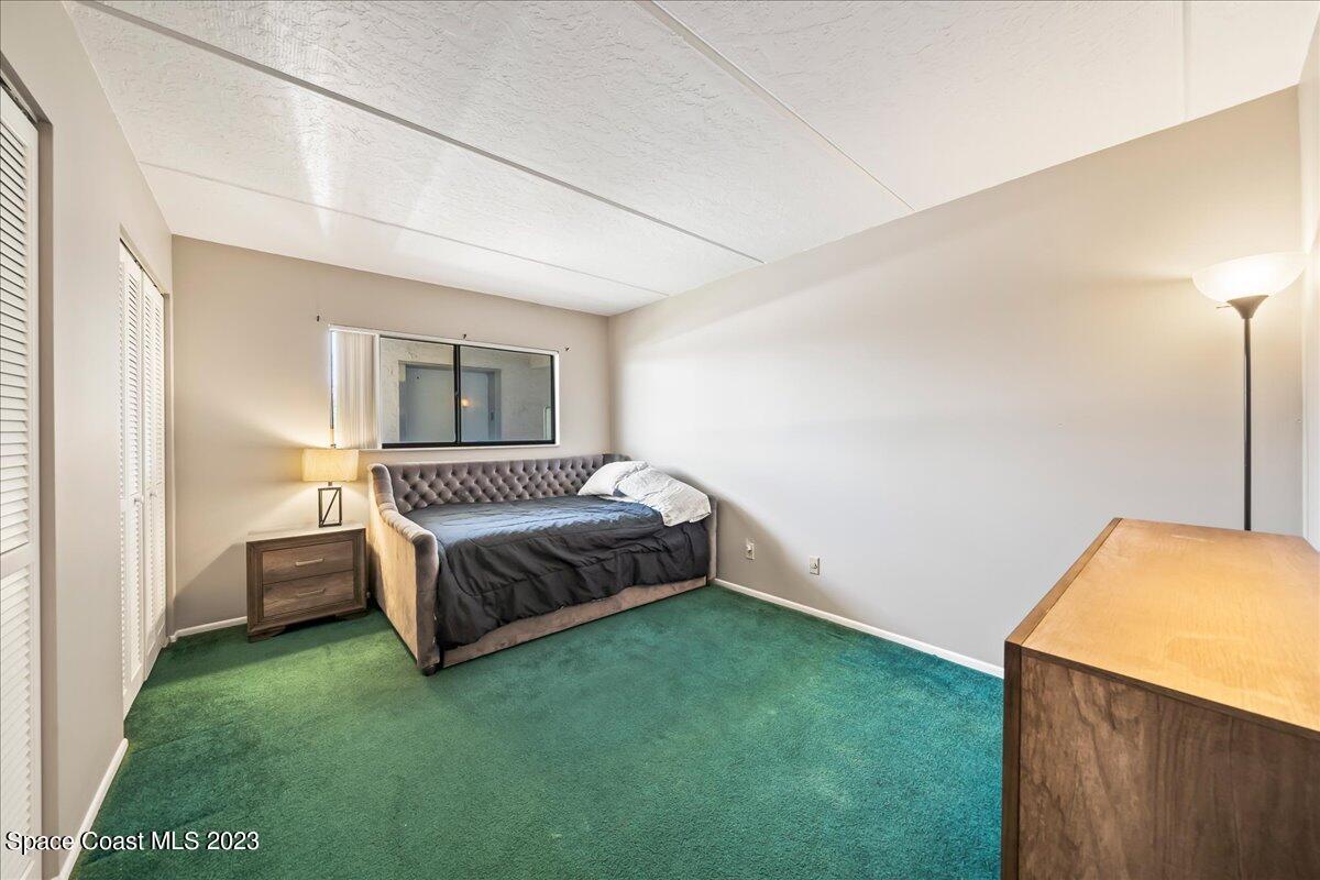 2775 North Wickham Road, Unit 204 Melbourne, FL 32935 - Photo 17 of 24 a spacious bedroom with a bed and a cabinets