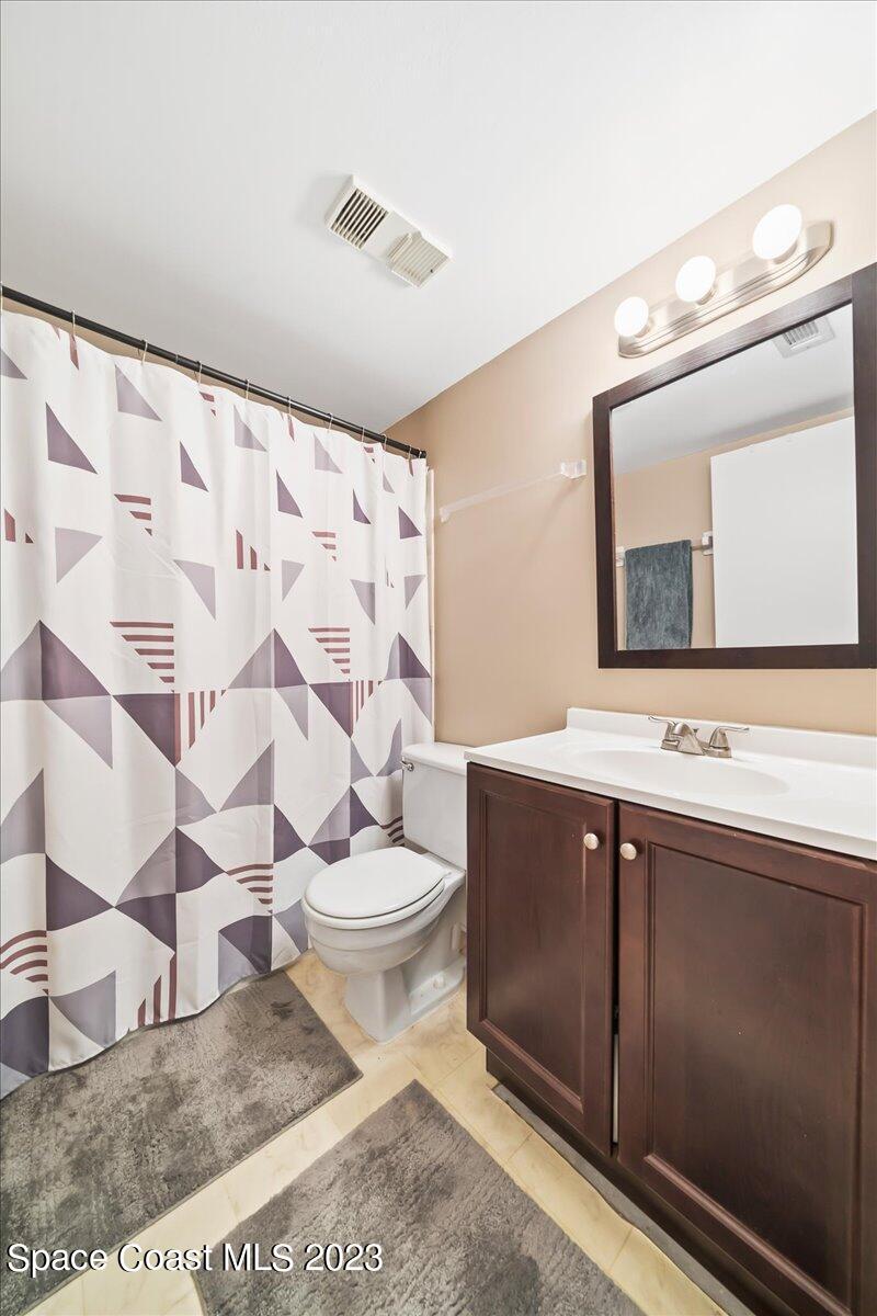 2775 North Wickham Road, Unit 204 Melbourne, FL 32935 - Photo 18 of 24 a bathroom with a toilet sink and mirror
