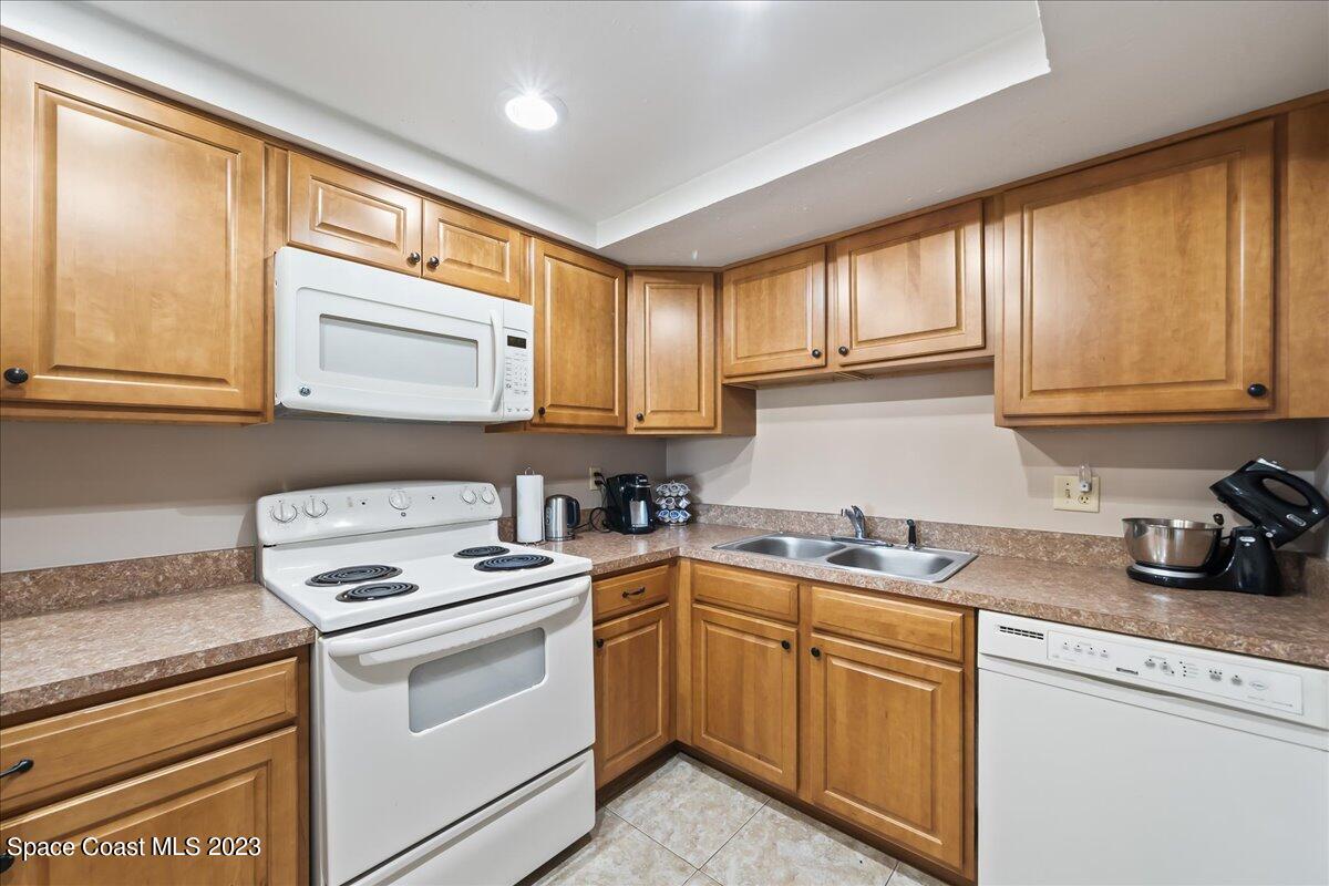 2775 North Wickham Road, Unit 204 Melbourne, FL 32935 - Photo 3 of 24 a kitchen with cabinets appliances a sink and a window
