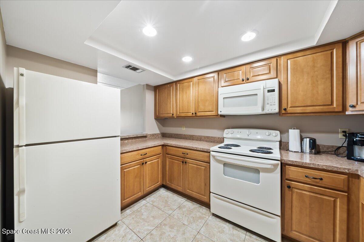 2775 North Wickham Road, Unit 204 Melbourne, FL 32935 - Photo 4 of 24 a kitchen with appliances a refrigerator and a sink