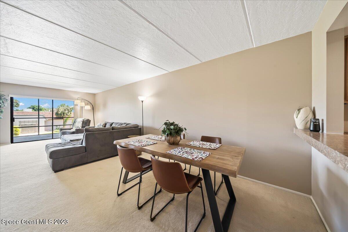 2775 North Wickham Road, Unit 204 Melbourne, FL 32935 - Photo 6 of 24 a view of a dining room with furniture wooden floor and a carpet