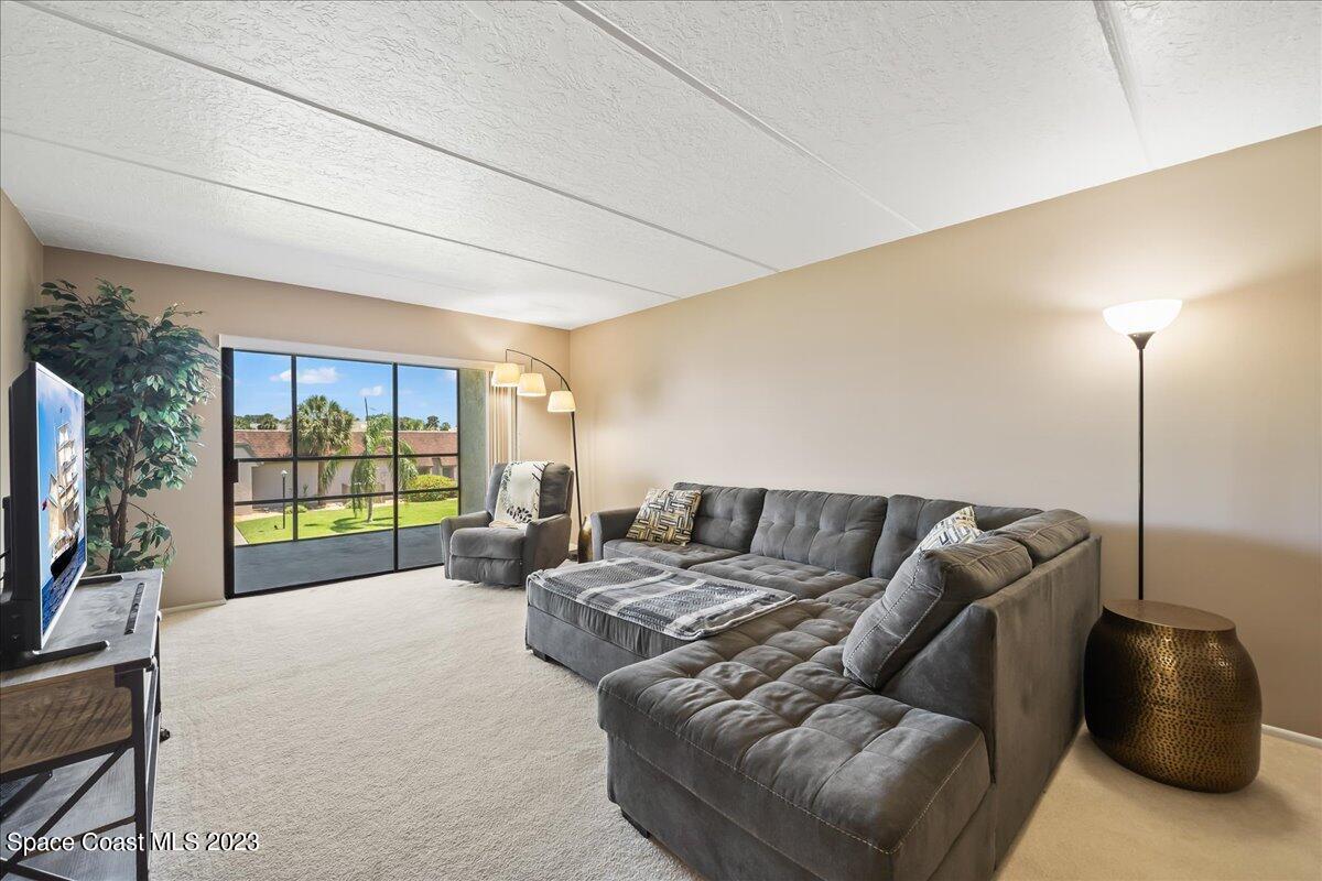2775 North Wickham Road, Unit 204 Melbourne, FL 32935 - Photo 9 of 24 a living room with furniture window and a flat screen tv