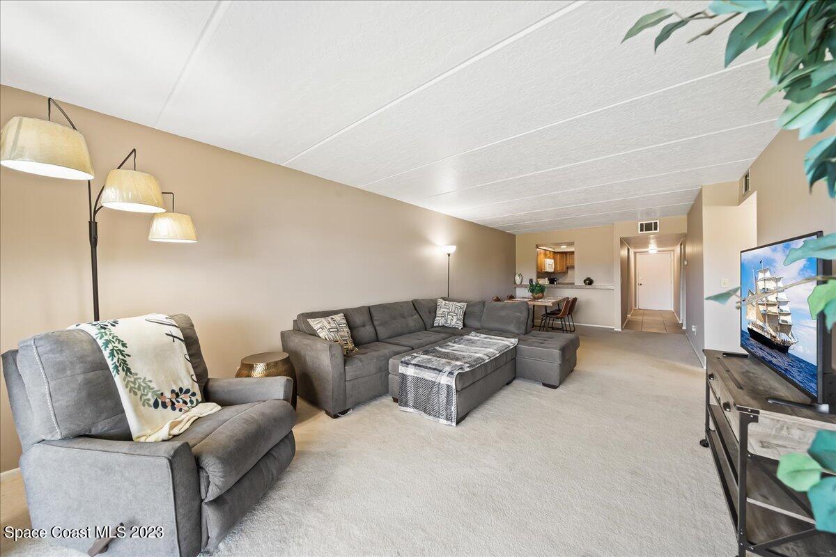 2775 North Wickham Road, Unit 204 Melbourne, FL 32935 - Photo 10 of 24 a living room with furniture and a flat screen tv
