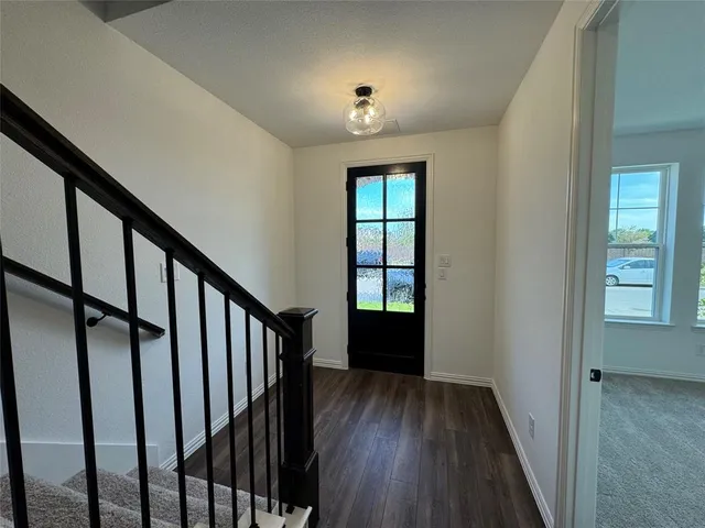 a view of hallway with wooden floor and stairs