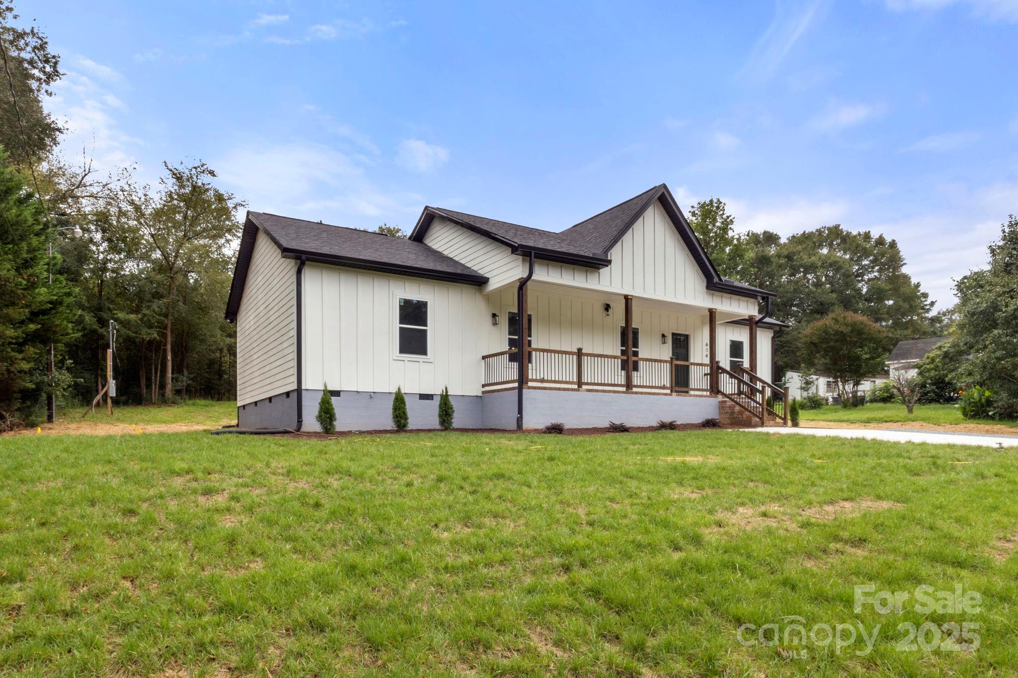 614 Hardin Road Dallas, NC 28034 - Photo 4 of 37 a front view of a house with a garden and trees