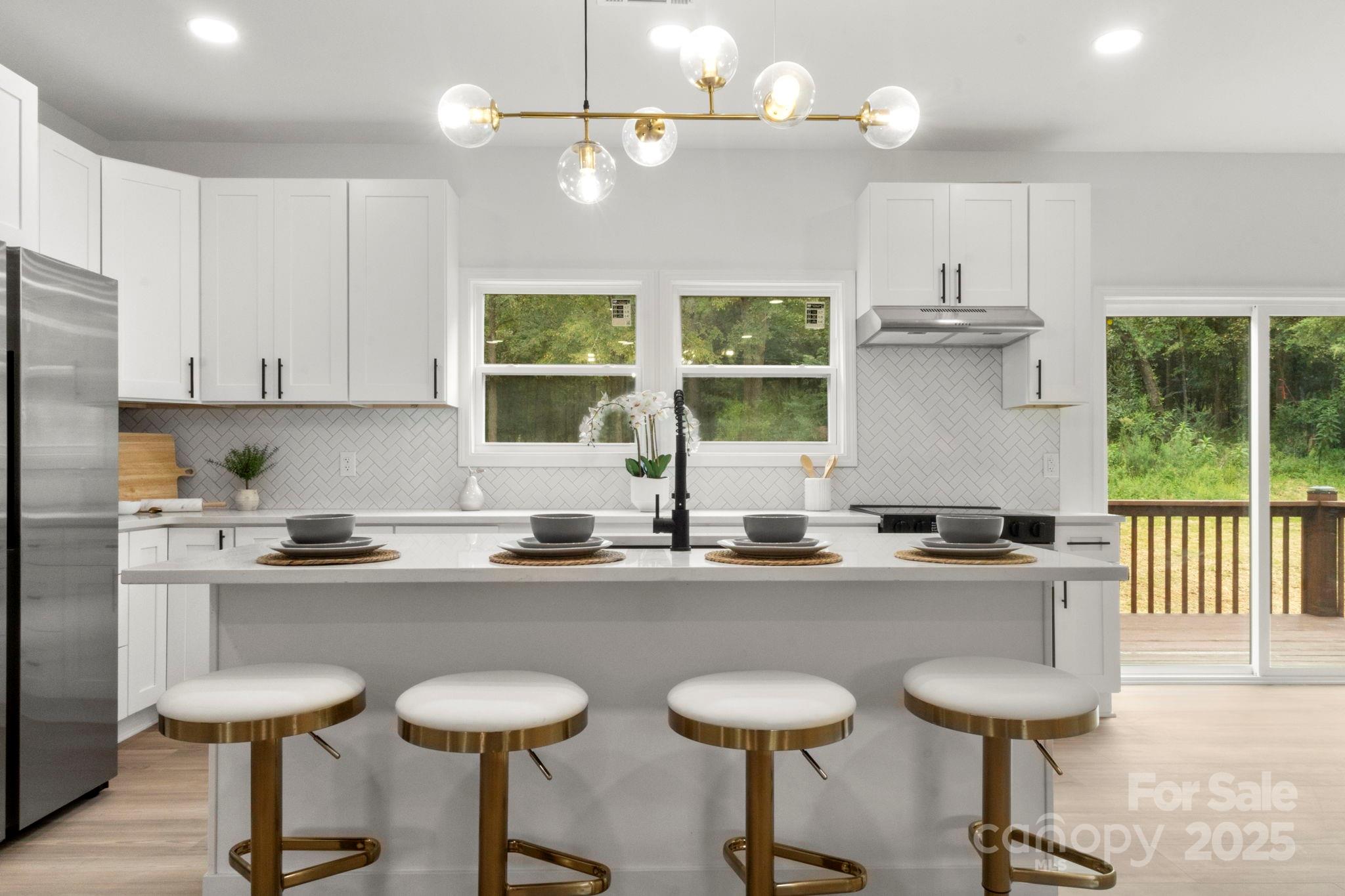 614 Hardin Road Dallas, NC 28034 - Photo 10 of 37 a kitchen with stainless steel appliances granite countertop a sink a stove and chairs