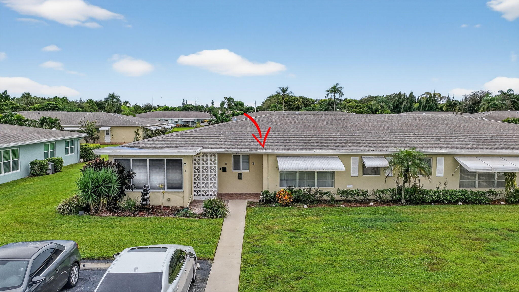 242 West High Point Court, Unit B Delray Beach, FL 33445 - Photo 29 of 36 a front view of a house with a yard