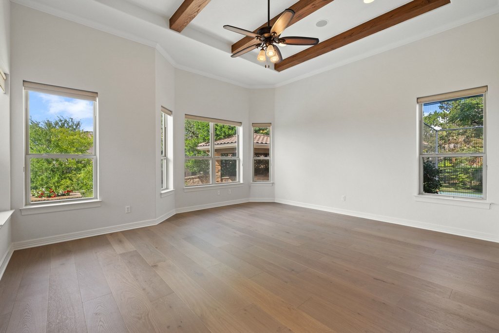 109 Largo Cove Austin, TX 78734 - Photo 19 of 40 Exposed wood beams adorn the ceiling of this airy living space, complementing the rich hardwood floors.