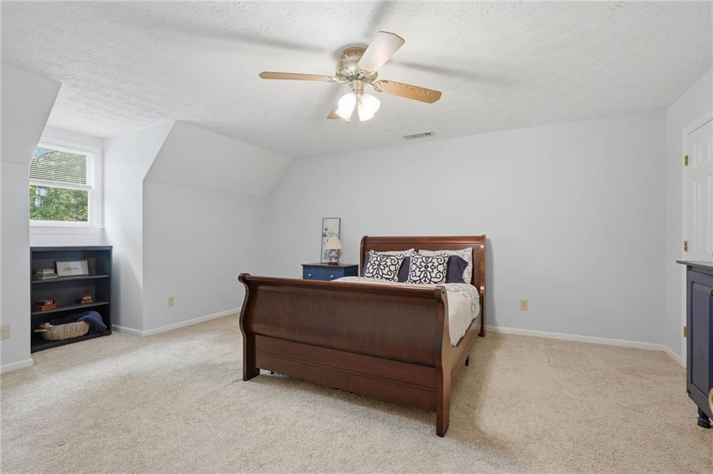 4891 Bill Cheek Road Auburn, GA 30011 - Photo 39 of 99 a bed room with a bed and a ceiling fan