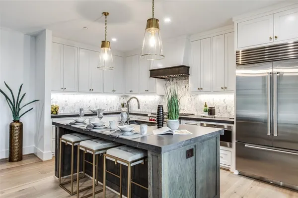 a kitchen with stainless steel appliances granite countertop a sink a stove and a refrigerator