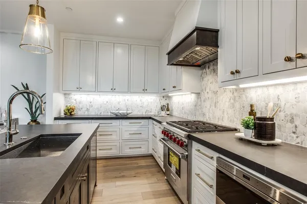 a kitchen with stainless steel appliances granite countertop a sink stove and cabinets