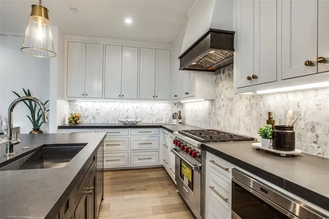 a kitchen with stainless steel appliances granite countertop a sink stove and cabinets
