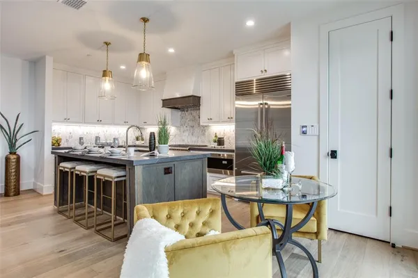 a kitchen with kitchen island granite countertop a table and chairs in it