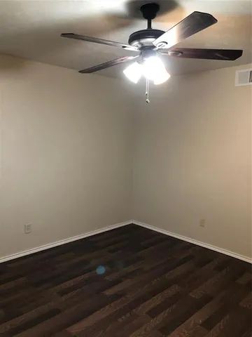 a view of room with hardwood floor and ceiling fan