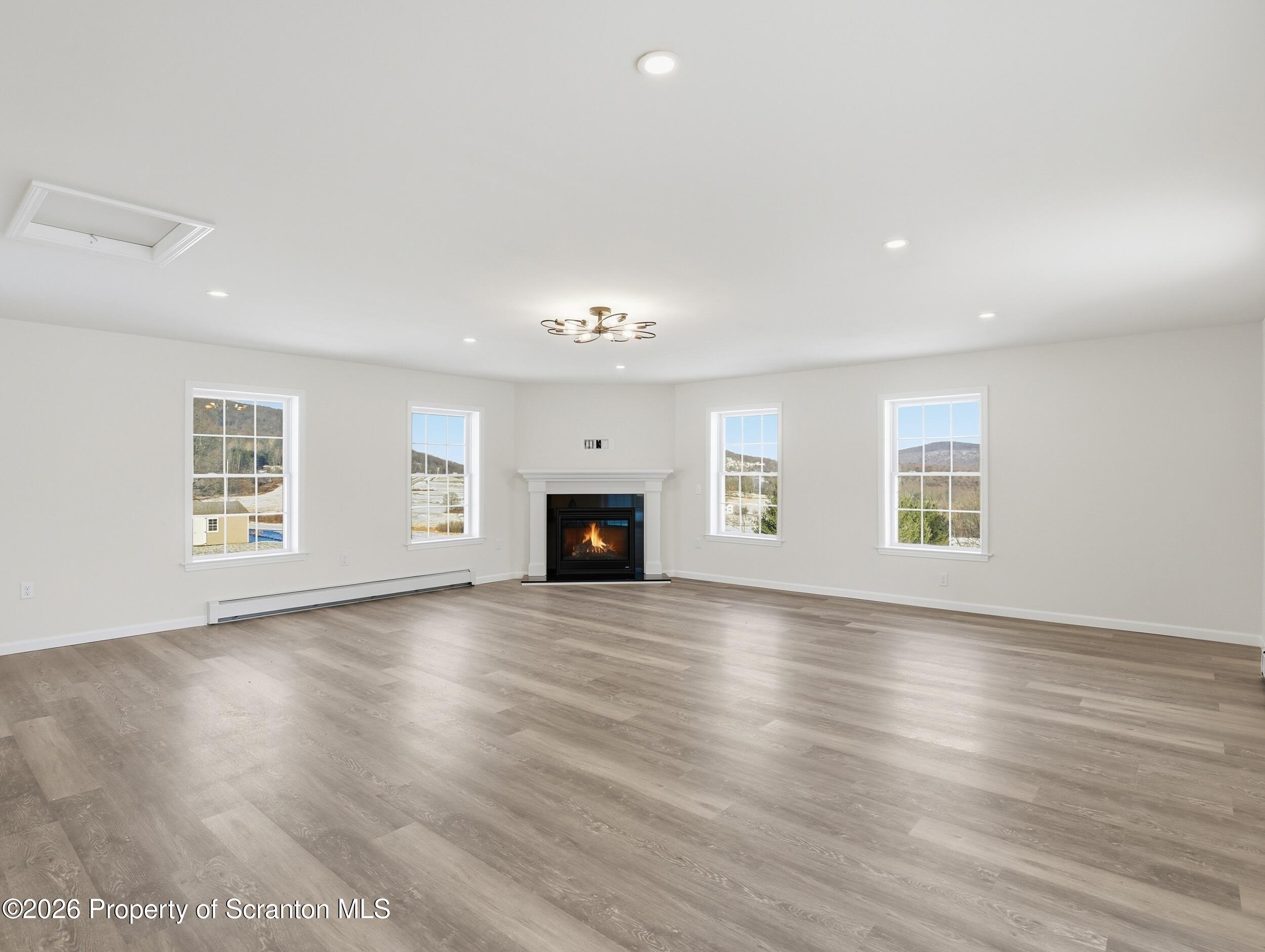167 Braemar Terrace Tunkhannock, PA 18657 - Photo 17 of 41 an empty room with wooden floor fireplace and windows