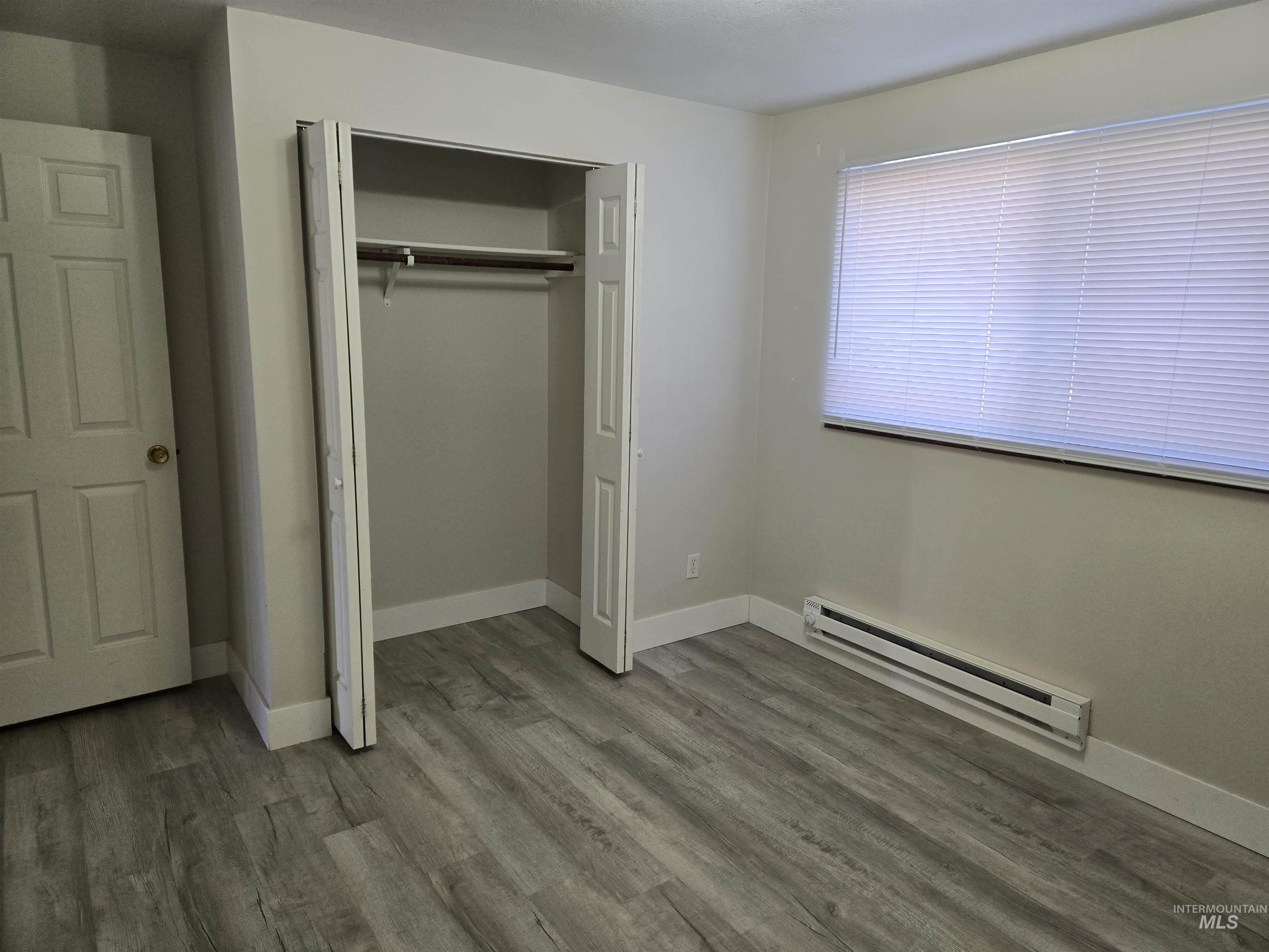 259 Pheasant Road West, Unit 50 Twin Falls, ID 83301 - Photo 18 of 23 Unfurnished bedroom with a baseboard radiator, wood finished floors, and a closet