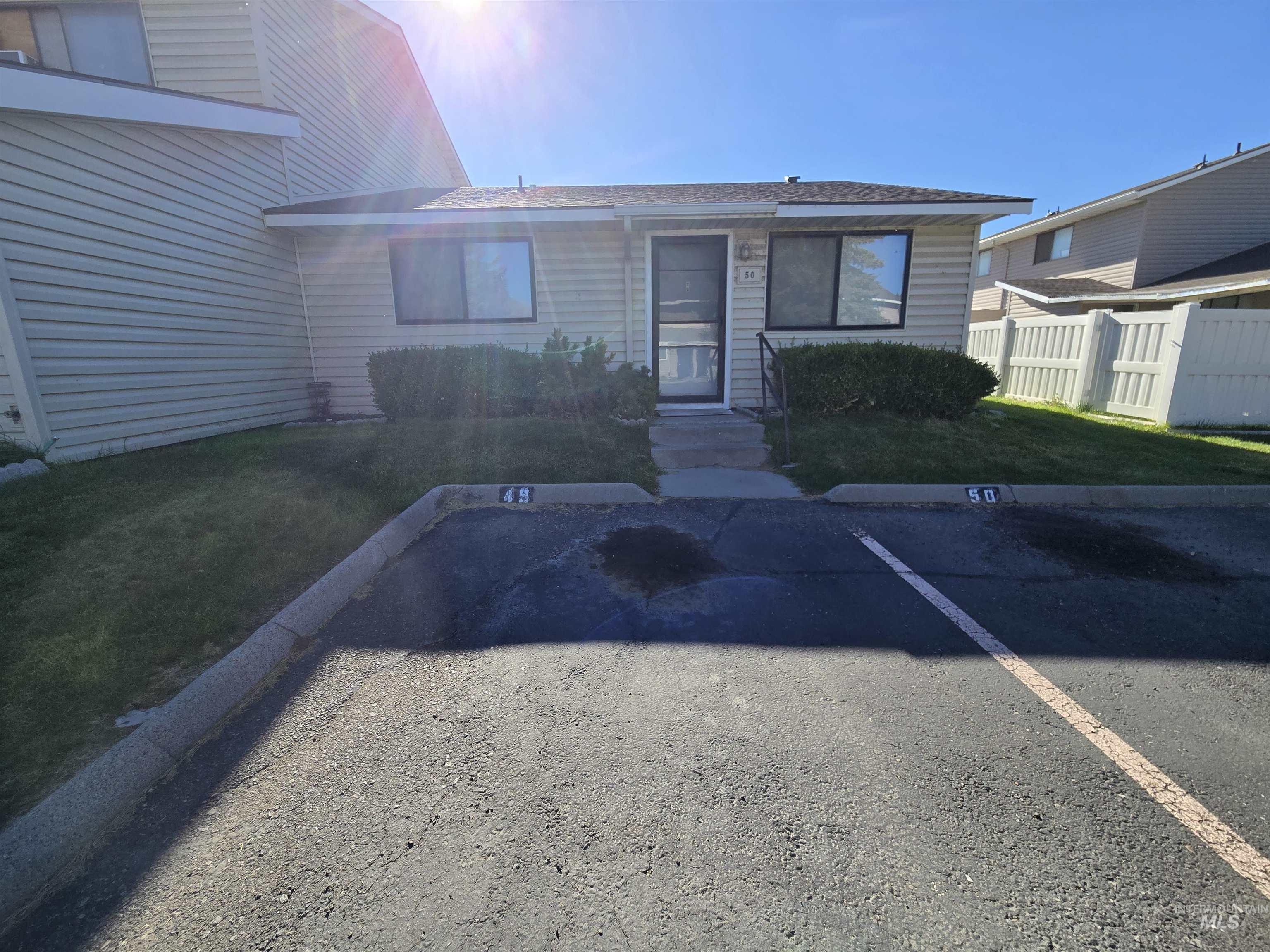 259 Pheasant Road West, Unit 50 Twin Falls, ID 83301 - Photo 4 of 23 View of exterior entry featuring uncovered parking and roof with shingles