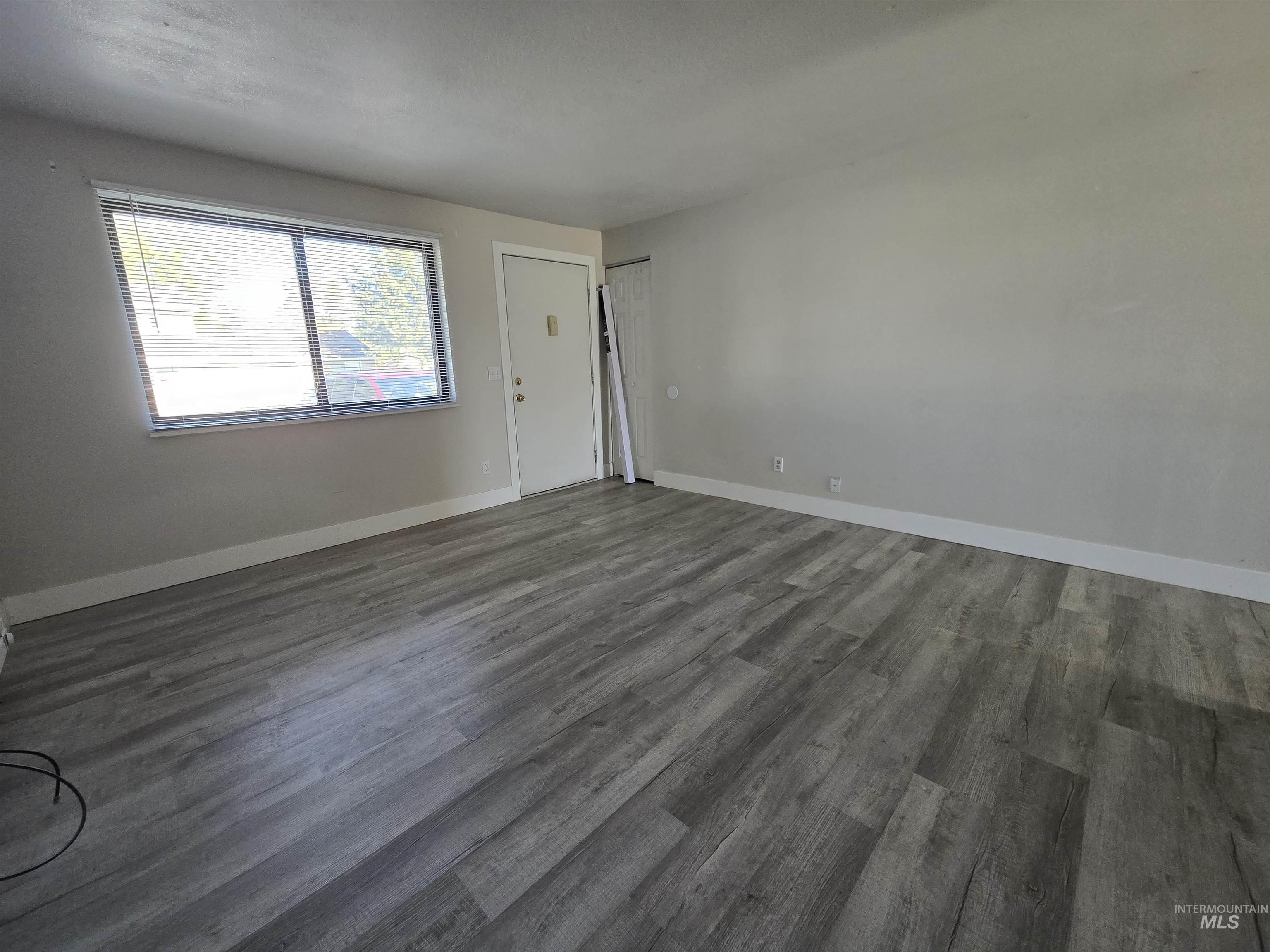 259 Pheasant Road West, Unit 50 Twin Falls, ID 83301 - Photo 7 of 23 Empty room featuring dark wood-type flooring and baseboards