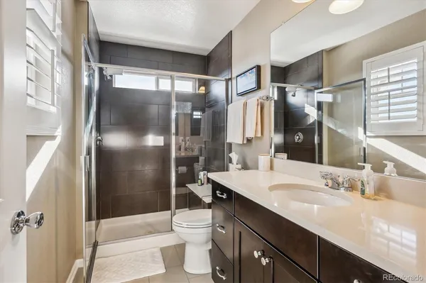 a bathroom with a granite countertop sink toilet and shower