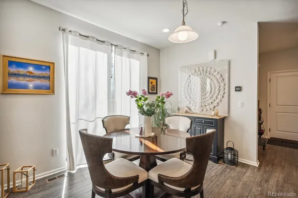 a dining room with furniture and wooden floor