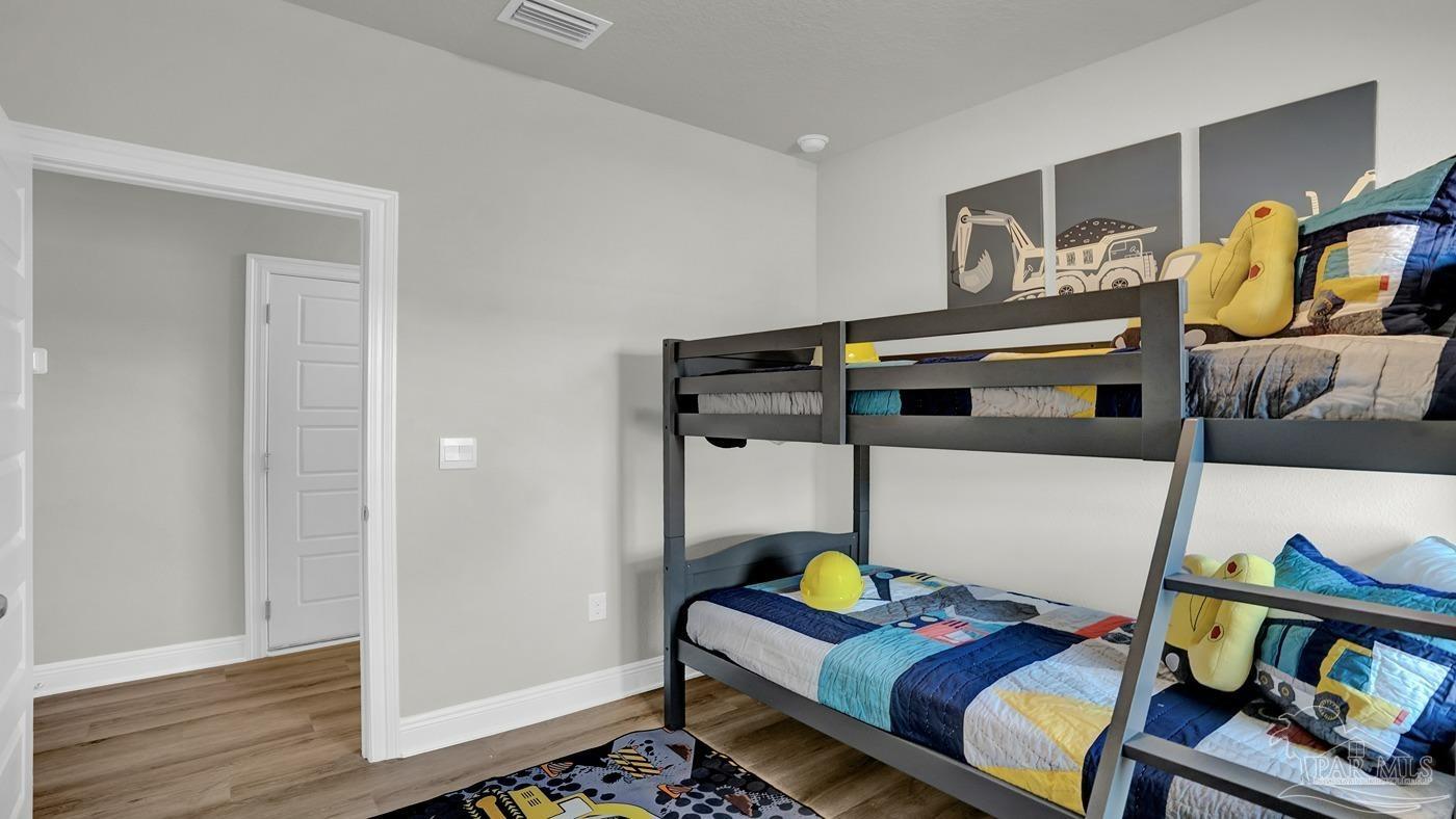 24 Spoonbill Street Cantonment, FL 32533 - Photo 11 of 30 a bedroom with a bed and wooden floor