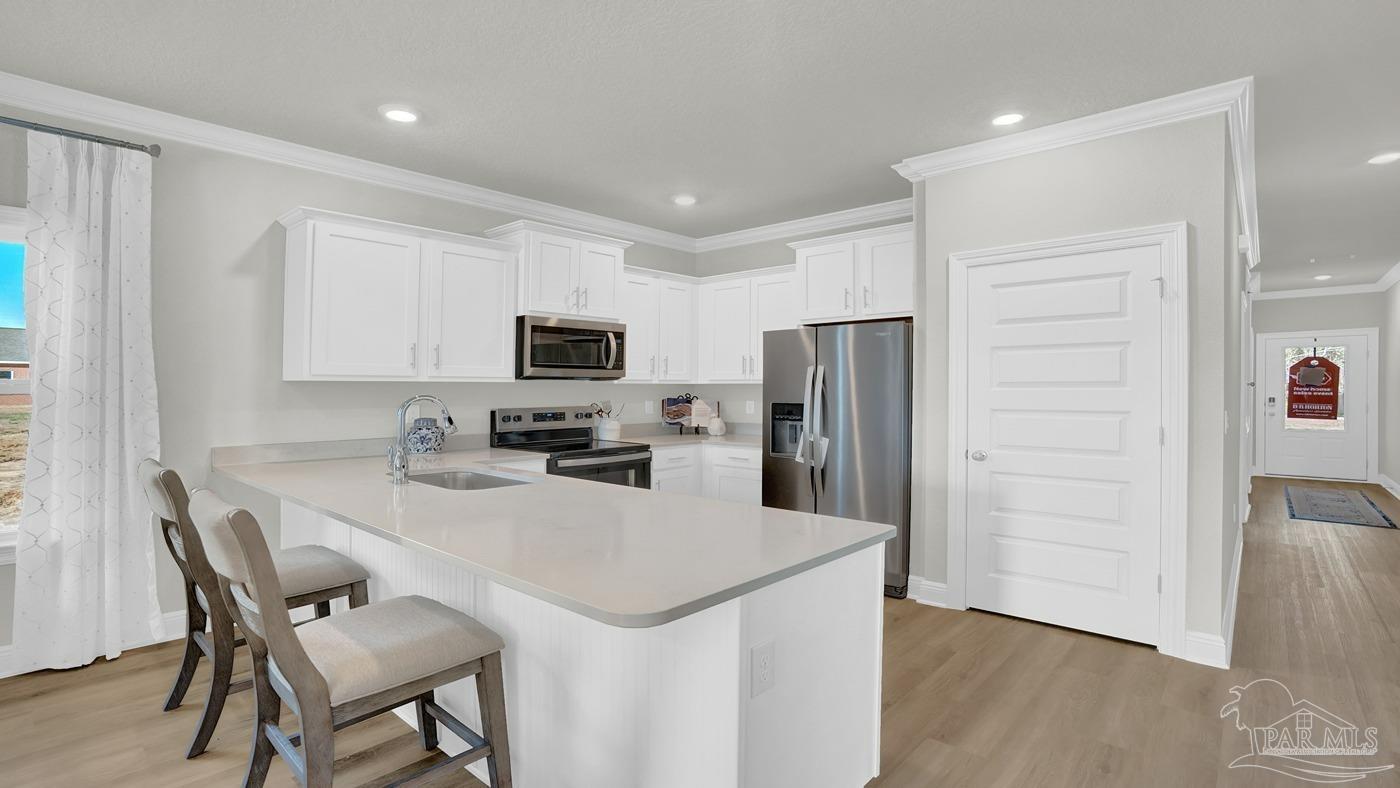 24 Spoonbill Street Cantonment, FL 32533 - Photo 19 of 30 a kitchen with a refrigerator a stove a sink and dishwasher with wooden floor