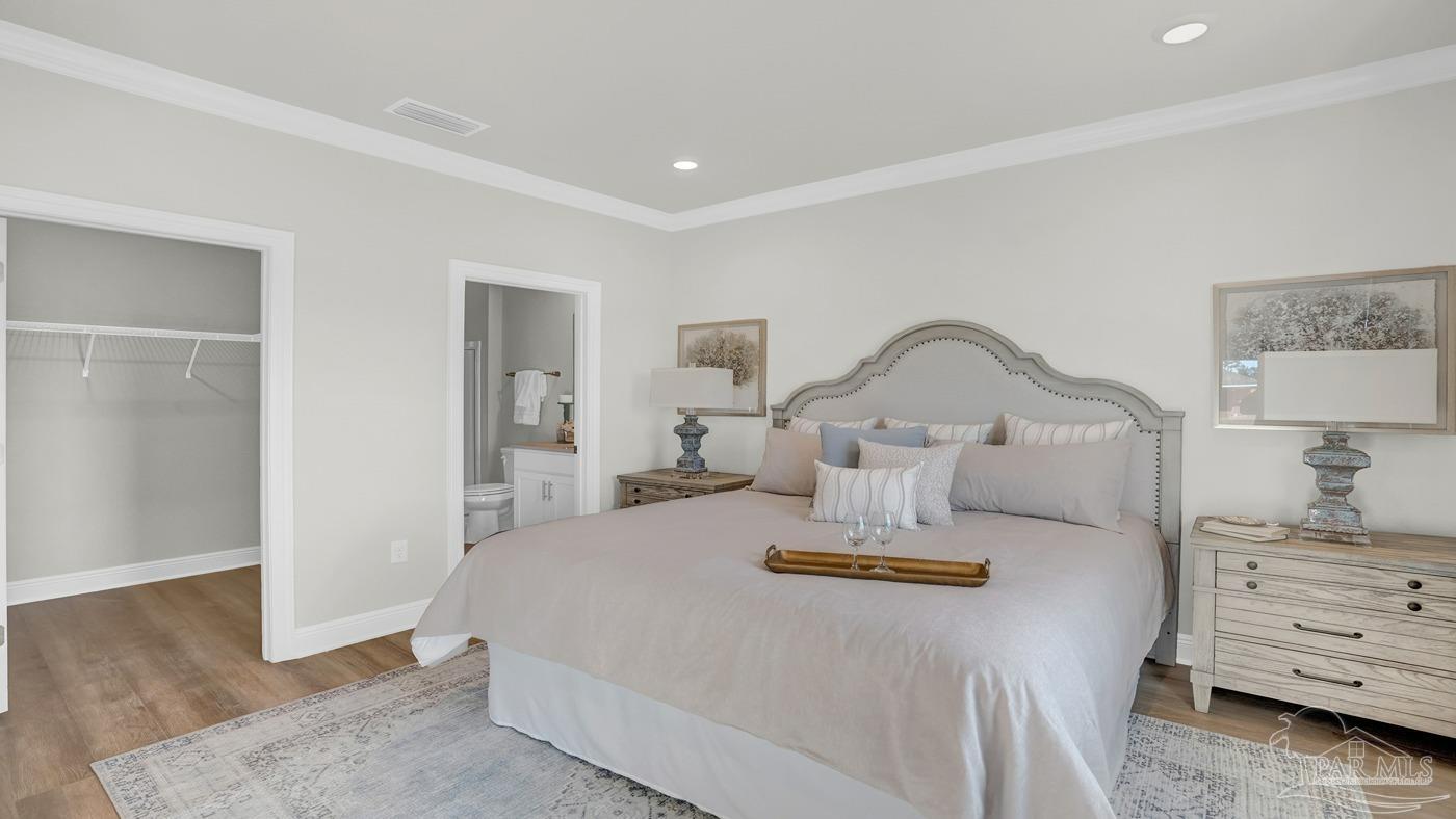 24 Spoonbill Street Cantonment, FL 32533 - Photo 26 of 30 a bedroom with a bed a mirror on dresser and a table