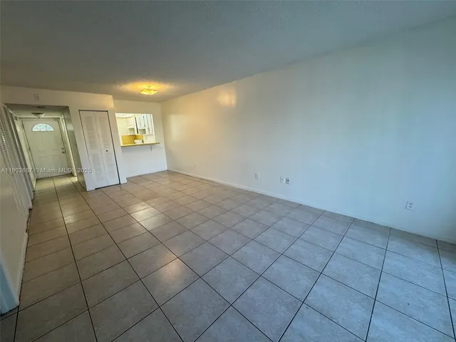a view of a livingroom with an empty space and a window