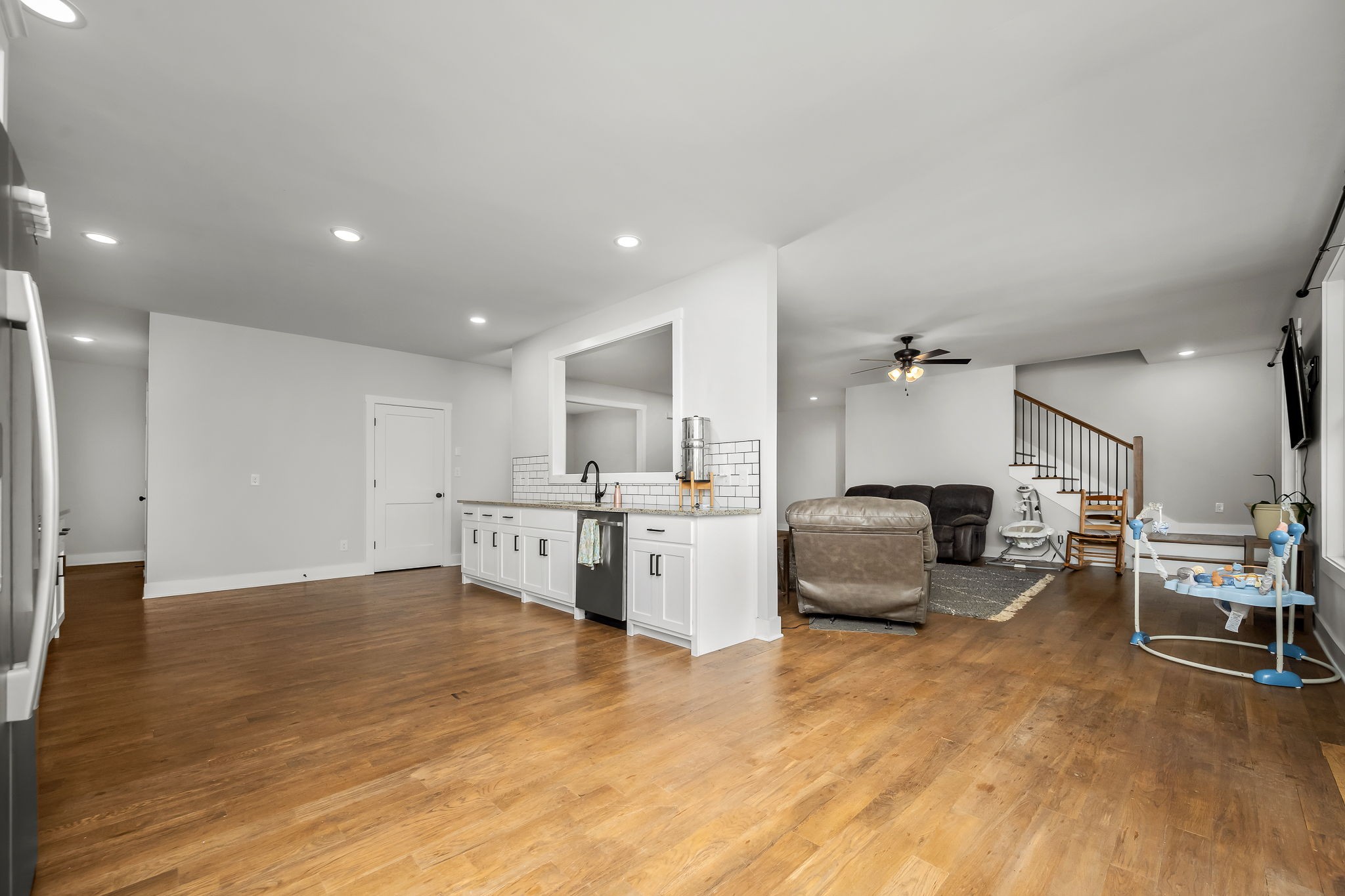 3880 Short Mountain Road Woodbury, TN 37190 - Photo 16 of 59 a large white kitchen with a stove a sink dishwasher and a fireplace with wooden floor