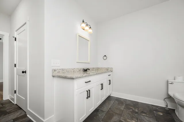 a bathroom with a granite countertop sink toilet and shower