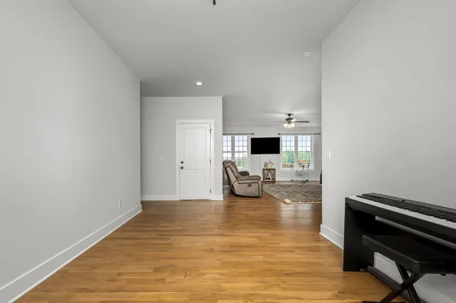 a living room with furniture a flat screen tv and a large window