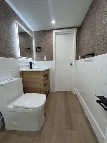 a bathroom with a toilet sink and mirror