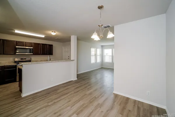 a view of a kitchen with a sink and dishwasher a oven with wooden floor