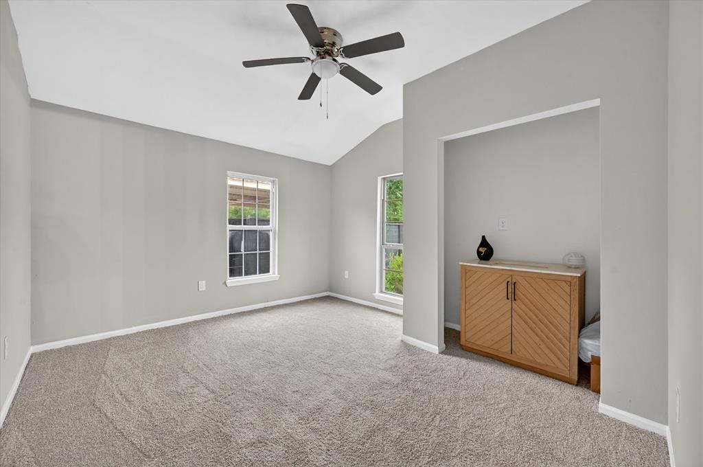 538 Pemberton Hill Road Dallas, TX 75217 - Photo 12 of 31 Spacious room featuring vaulted ceilings, a ceiling fan, plush carpeting, and two windows