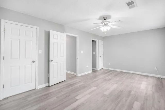 a view of an empty room with wooden floor