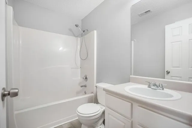 a bathroom with a sink toilet vanity and shower