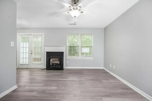 an empty room with windows and a fireplace
