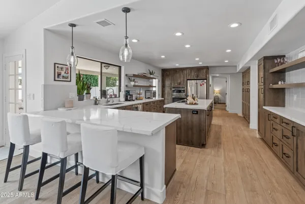 a kitchen with kitchen island a sink stove and wooden floor