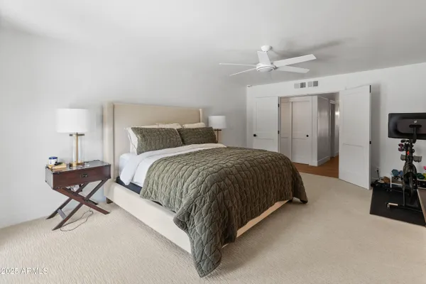 a bedroom with a bed and a large mirror