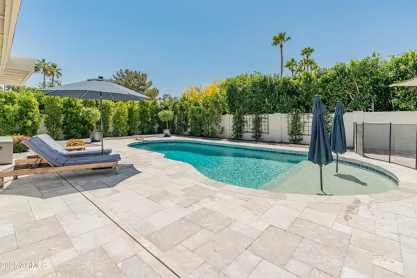 a view of a patio with a table and chairs under an umbrella