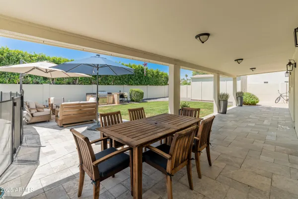 a view of a patio with couches and table under an umbrella