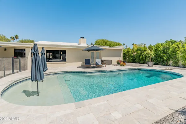a view of a house with backyard and sitting area
