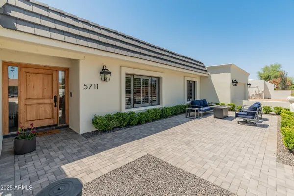 a view of a terrace with furniture and a garden