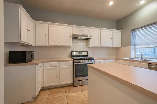 a kitchen with cabinets appliances and a window
