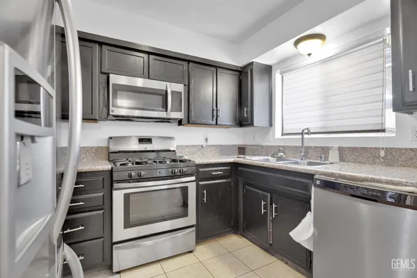 a kitchen with stainless steel appliances granite countertop a refrigerator stove and sink