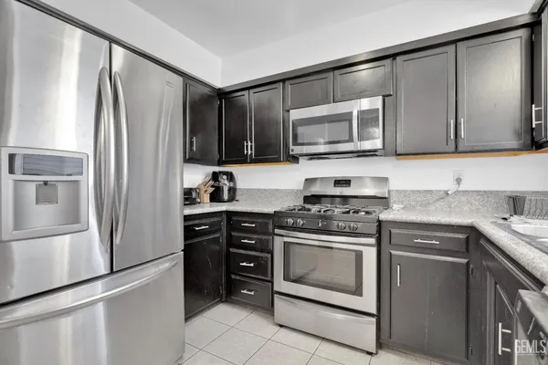a kitchen with stainless steel appliances granite countertop a stove a sink and a microwave