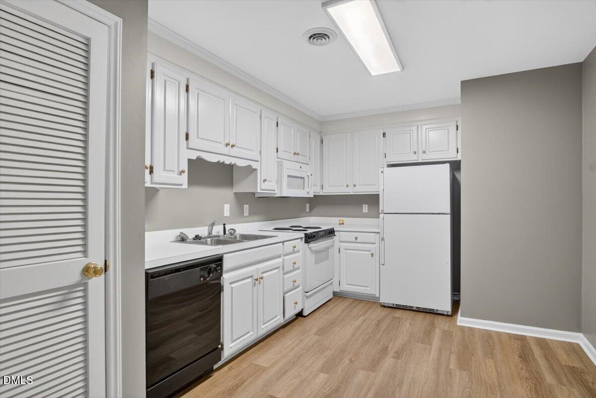1630 Oxford Road, Unit F Henderson, NC 27536 - Photo 11 of 33 a kitchen with white cabinets sink and white appliances